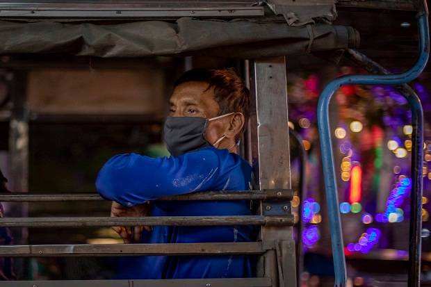在泰国曼谷的建筑工人在卡车上面戴口罩